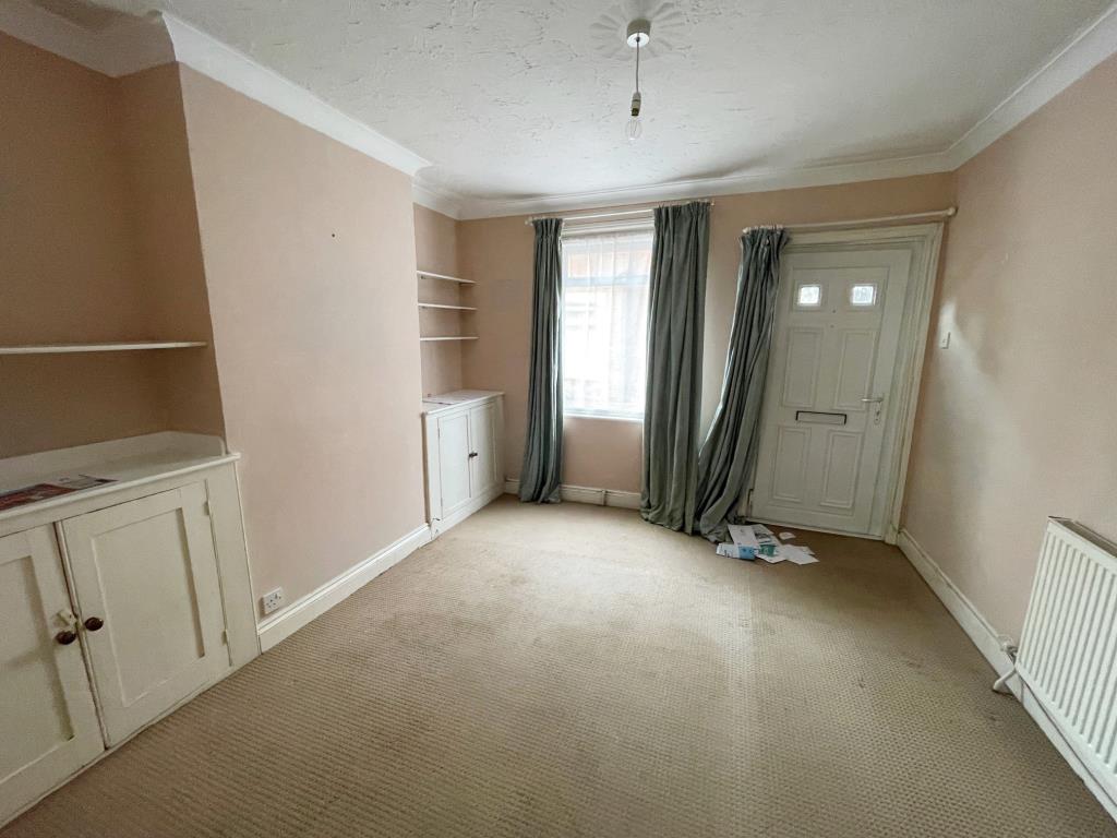 Lot: 126 - TERRACE HOUSE FOR IMPROVEMENT IN COLCHESTER CITY CENTRE - Living room with front door, window to front and radiator